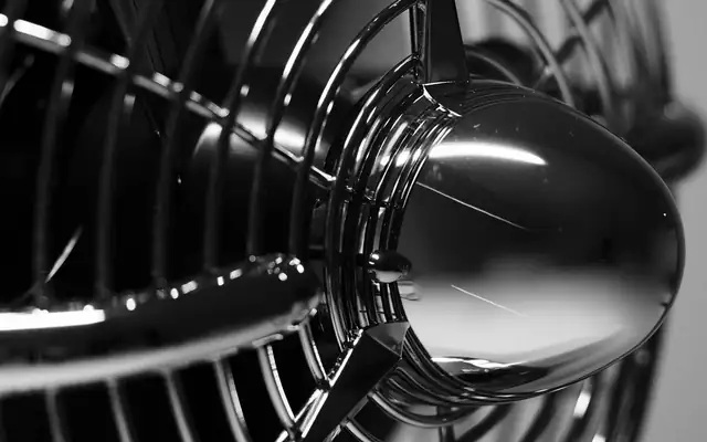 Close-up of a metal fan grille in black and white