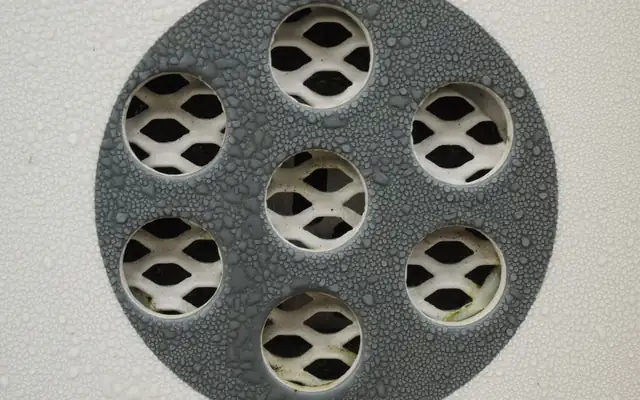 Close-up of a wet metal floor drain